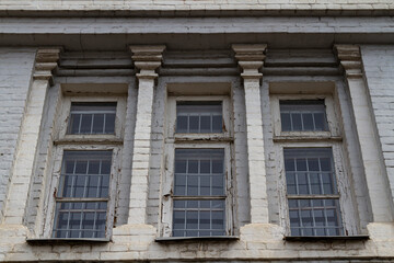 Obraz premium Traditional brickwork architecture showcasing weathered windows and decorative pilasters