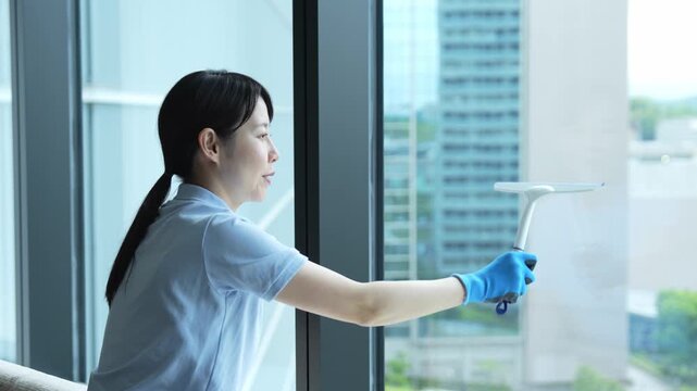 窓ガラスをふく女性