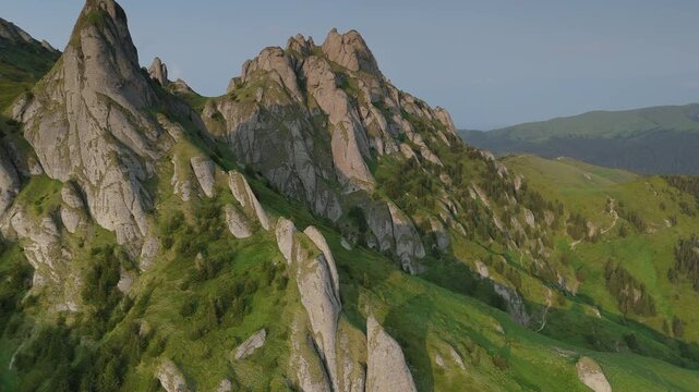 Spectacular Tigaile Mari conglomerate erosion towers in the Ciucas Mountains during golden hour sunset, ascending aerial flight with close up pass between rocks, graded