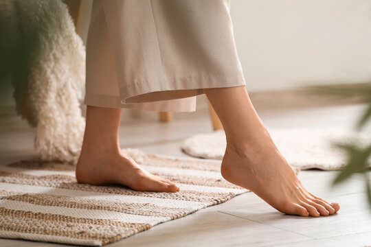 Young woman with flat feet on carpet at home, closeup