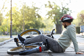 Sporty young man fallen off his bike in park © Pixel-Shot