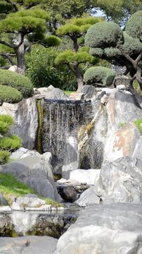 Close up of small waterfall flowing over rocks vertically
