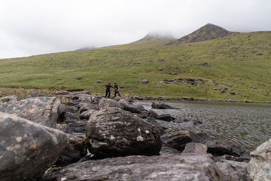 Hikers navigating rocky path at carrauntoohil lake