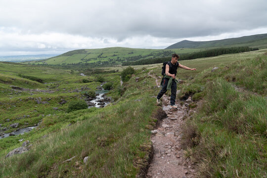 Young hiker trekking rocky mountain trail in ireland
