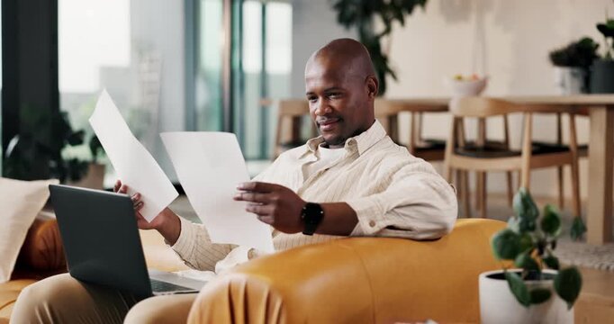 Laptop, remote work and document with black man on couch in living room for small business in home. Tech, paperwork and report with freelancer in apartment for startup research, proposal or review