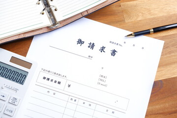 請求書 - 取引先へ宛てて請求書を準備する、ビジネスシーンのイメージ  © PJM