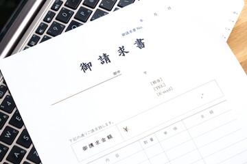 請求書 - 取引先へ宛てて請求書を準備する、ビジネスシーンのイメージ  © PJM