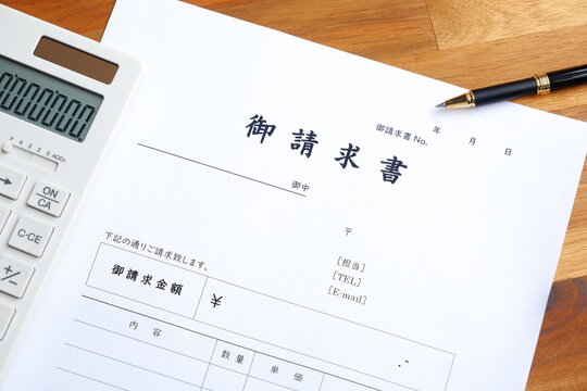 請求書 - 取引先へ宛てて請求書を準備する、ビジネスシーンのイメージ

