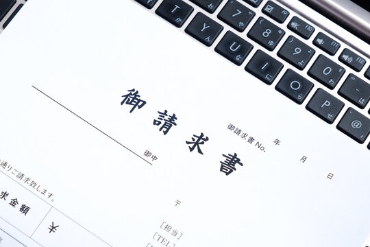 請求書 - 取引先へ宛てて請求書を準備する、ビジネスシーンのイメージ
