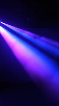 Animated projections of vibrant purple and blue stage spotlights with dynamic beam effects creating a lively performance atmosphere.