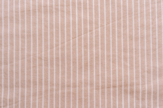 Beige striped fabric texture in close up.
