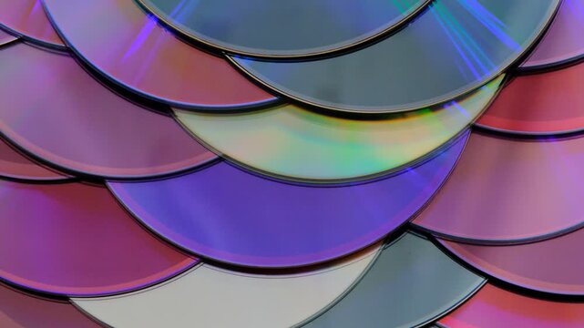 Reflection of the surface of a DVD discs, multiple optical discs stacked on top of each other like fish scales, colorful lines on the surface are caused by thin-film interference and diffraction