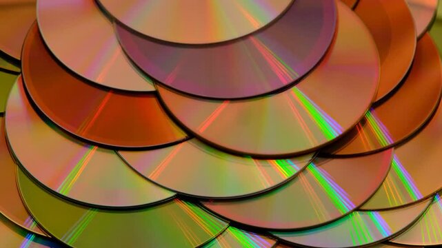 Reflection of the surface of a DVD discs, multiple optical discs stacked on top of each other like fish scales, colorful lines on the surface are caused by thin-film interference and diffraction