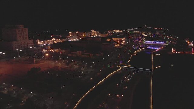 Night Aerial View of Riverside Buildings with Illuminated Signs