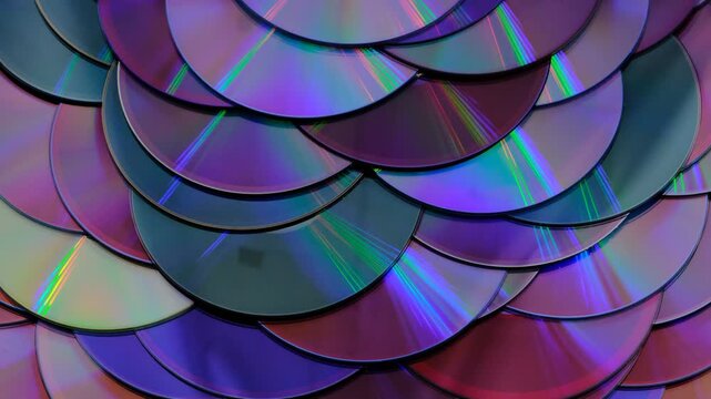 Reflection of the surface of a DVD discs, multiple optical discs stacked on top of each other like fish scales, colorful lines on the surface are caused by thin-film interference and diffraction