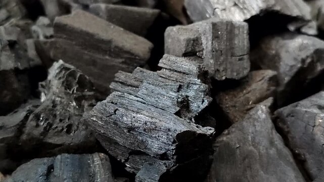 A collection of charcoal. Charcoal is a black, carbonaceous residue produced by burning wood without oxygen (pyrolysis). This material is widely used as a cooking fuel
