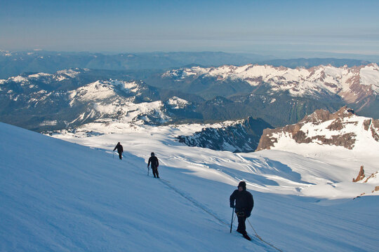 Three climbers cross glacier en route to Mount Baker.