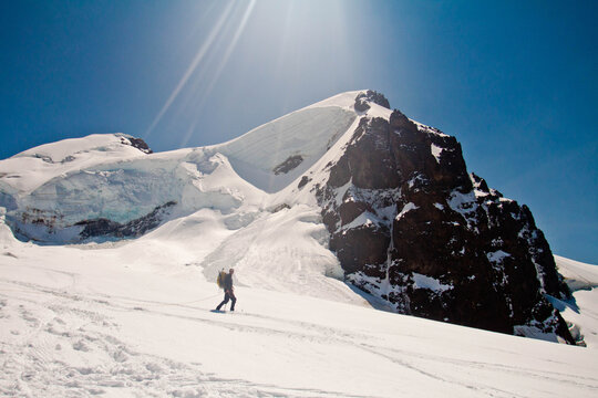 Mountaineer ascends a vast snowy mountain