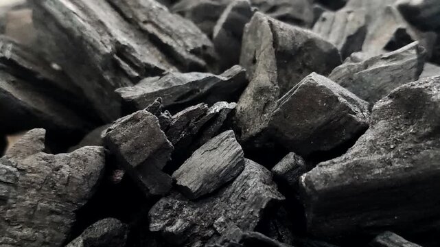 A collection of charcoal. Charcoal is a black, carbonaceous residue produced by burning wood without oxygen (pyrolysis). This material is widely used as a cooking fuel