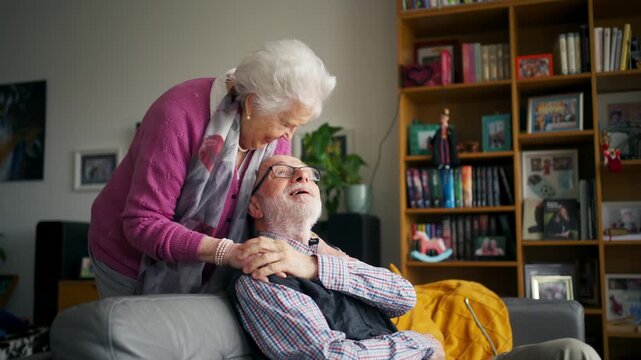 Elderly partners relaxing on sofa after sunday lunch.