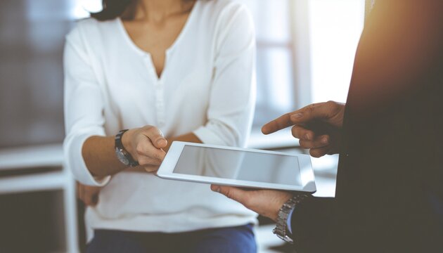 Creative team collaborating around digital tablet, innovation and teamwork concept
