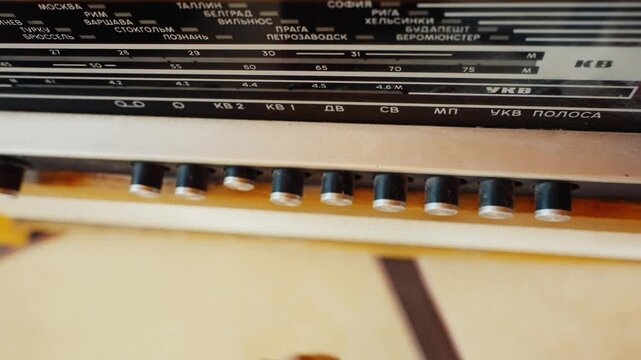 Person changing stations pressing buttons on vintage soviet radio