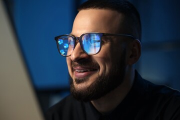 Fototapeta premium Smiling young man wearing glasses with data charts reflected, business analytics and digital technology