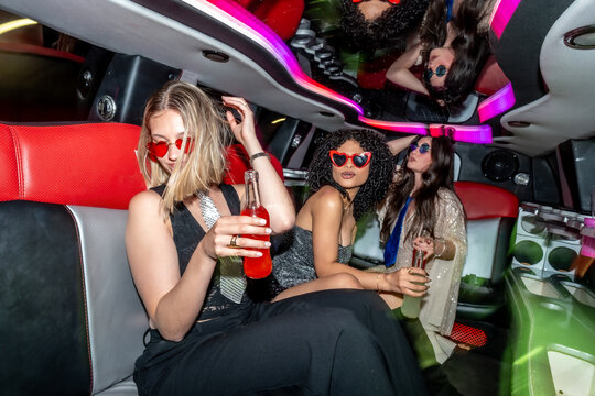 Young women celebrating in a limousine at night