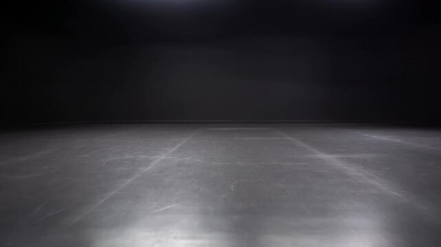 Slow tracking push shot of empty black studio floor reflecting overhead lights in indoor rehearsal theater soundstage room with glossy surface and subtle spotlight