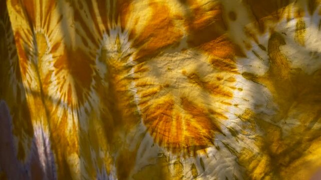 Vibrant Orange Tie Dye Sasirangan Fabric Hanging on 
Clothesline Drying in Sunlight.