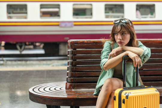 Young woman depressed mistakes a train. Female backpacker Traveler waiting at train station. Boarding the wrong ticket feeling stressed. Planning Fail trip tourist missing