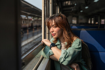 Fototapeta premium Freedom traveler beautiful woman at terminal train station. Happy tourist travel by train on vacation time holiday weekend trip. Female Backpacker arrival at platform railway.