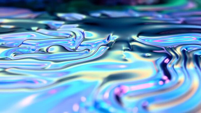 Slow motion tracking pan of iridescent liquid surface flowing and rippling on metallic oil film on studio tabletop close up with controlled lighting
