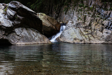 Sanzhanxi river in Taroko National Park. Small waterfall cascades into clear pool. Large granite rocks and lush green forest. Scenic landscape in Hualien, Taiwan. © Eugene Ga