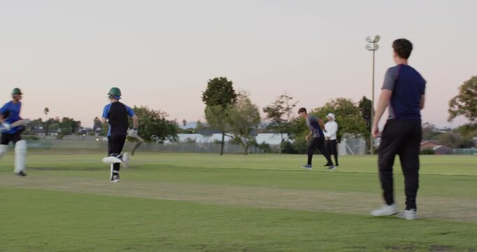 Boy batsman playing shot on cricket pitch, calling mate, sprinting, fielder returning ball