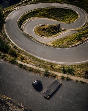 Top down aerial view of unique spiral downhill asphalt road used for extreme longboarding sports