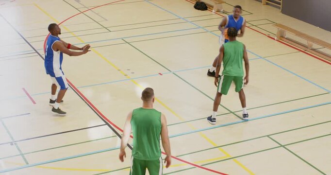 Male diving off bench in gym grabbing ball rolling toward line keeping play alive