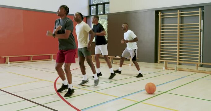 Doing drill, african american male training partners stepping around ball building agility in gym