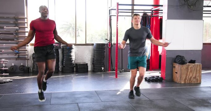 Diverse male friends jumping rope following warm-up cue adding hops crossovers, fist bump
