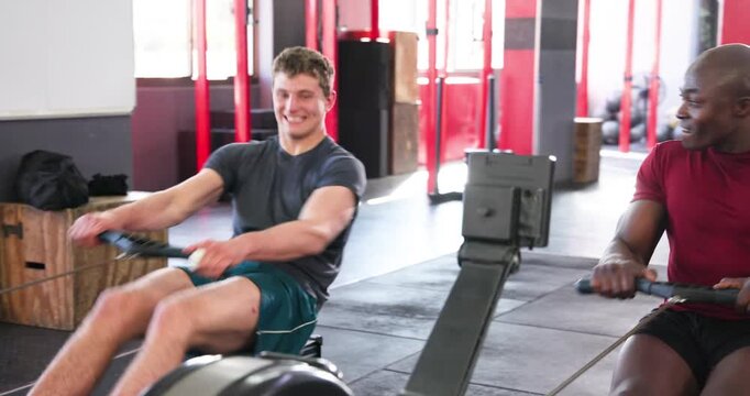 Diverse gym partner tightening straps mirroring strokes on rowers, fist bumping in gym training
