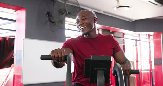 Diverse men in sportswear arriving, mounting gym stationary bikes and pedaling for cardio