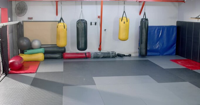 Camera panning right revealing rollers and exercise balls and punching bags showcasing gym