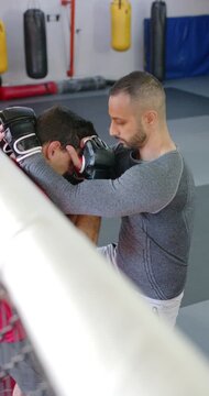 Diverse male training partners executing knee strikes as grey shirt man initiating clinch