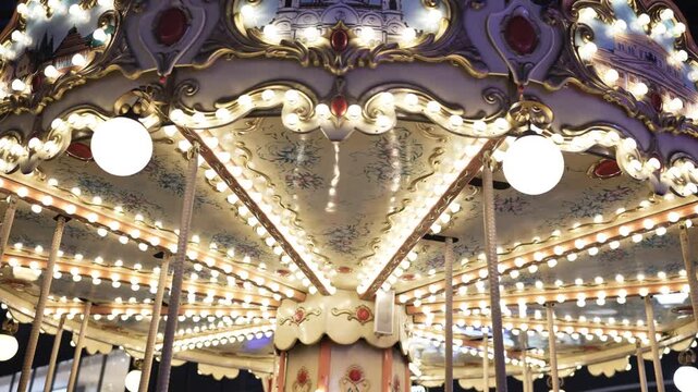 Vintage carousel lights illuminating an amusement park ride at night