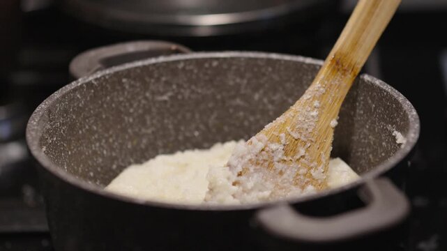 Cooking ghomi, a popular dish from the Samegrelo region made with coarse white corn flour