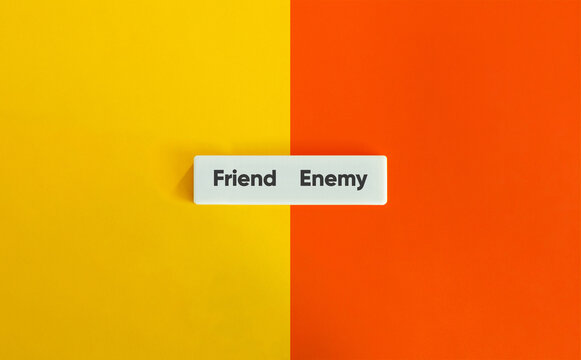 Friend enemy text white block split yellow orange background concept representing relationship duality conflict trust betrayal and frenemy psychology