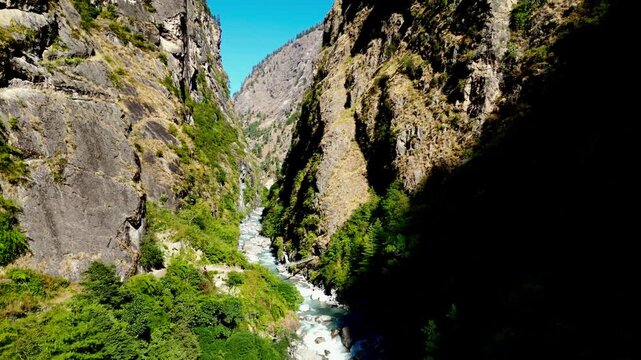 Aerial Flight Through Budhi Gandaki River Gorge with Suspension Bridge and Hikers Upstream from Nyak Village on Manaslu Circuit Trek, Nepal