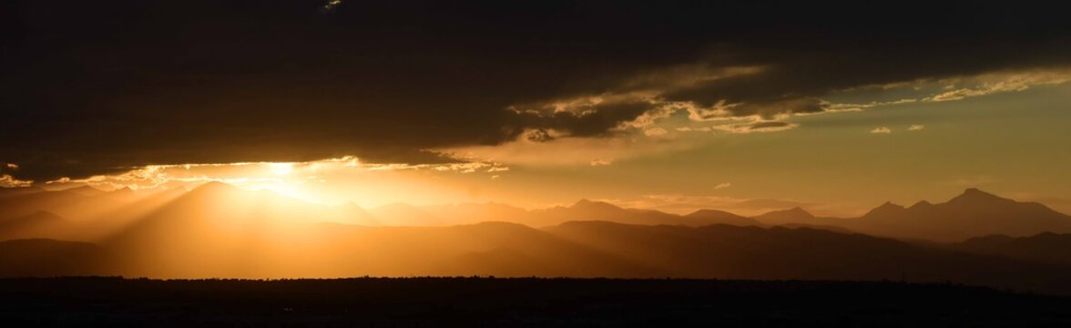 striking golden sunset  panorama of long's peak and  the front range of the colorado rocky mountains, as seen from broomfield, colorado