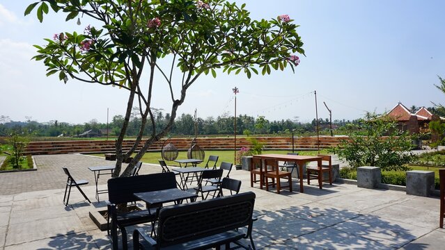 Cozy outdoor cafe terrace with garden tables and chairs.