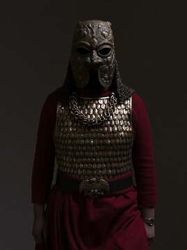 A warrior wearing an ancient Armenian Urartu bronze ceremonial mask with pomegranate vine engravings